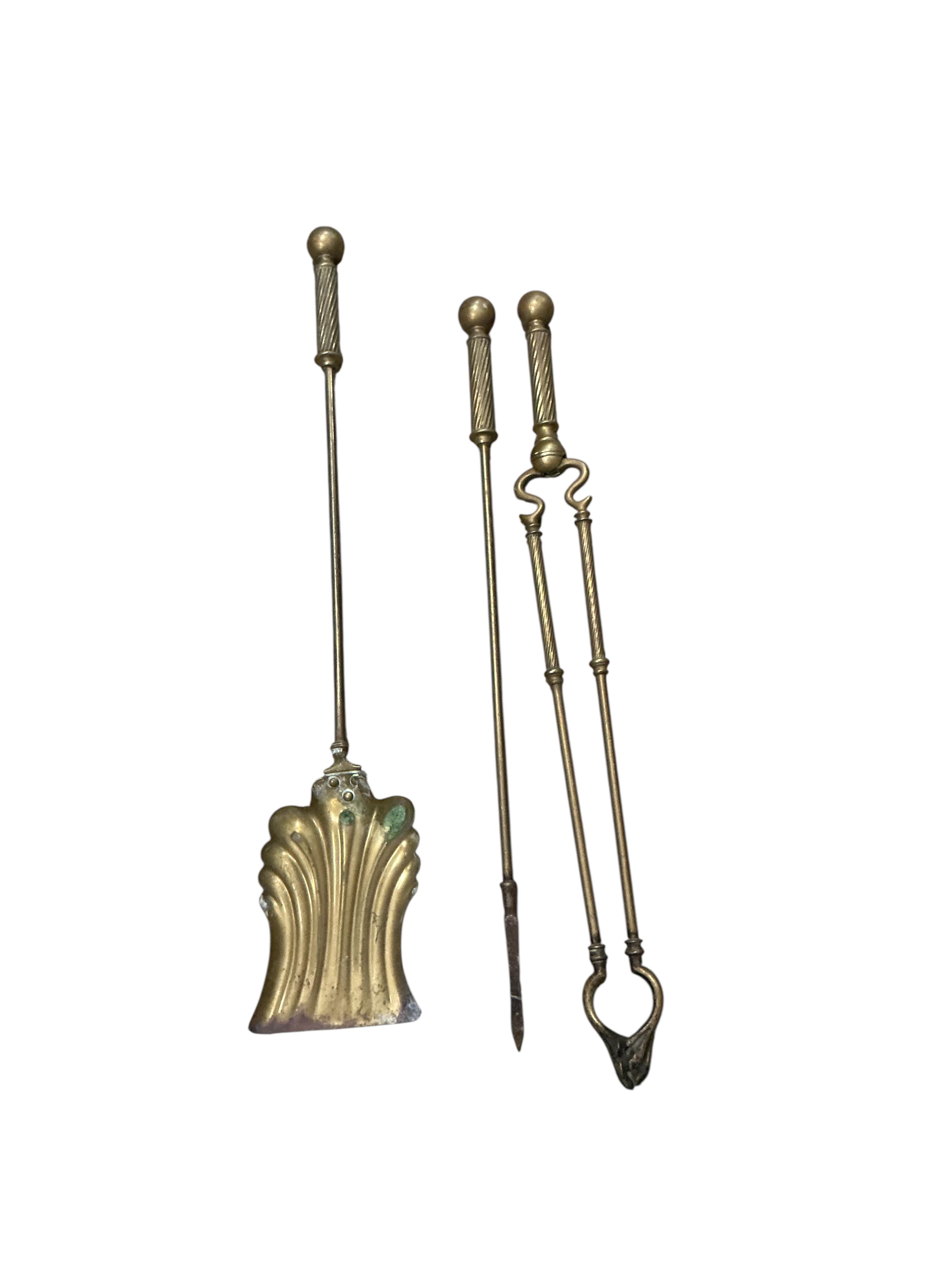 An Edwardian fender, a pair of wrought iron fire dogs and a set of brass implements